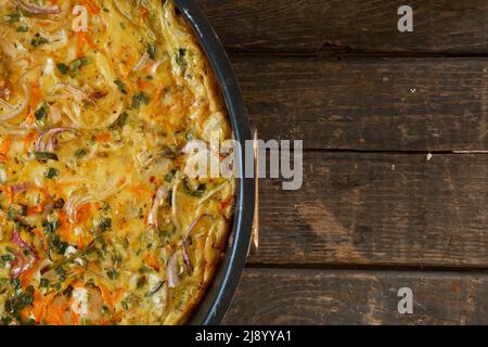 Torta a base di pesce, uova, cipolle e carote. Su tavole di legno. Vista dall'alto Foto Stock