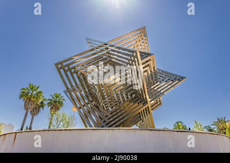 Huelva, Spagna - 28 aprile 2022: Il monumento a cubo in acciaio inossidabile nei giardini del Campus de “El Carmen” dell'Università di Huelva. Foto Stock