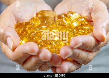 Le mani della donna tengono Omega 3 capsule Foto Stock