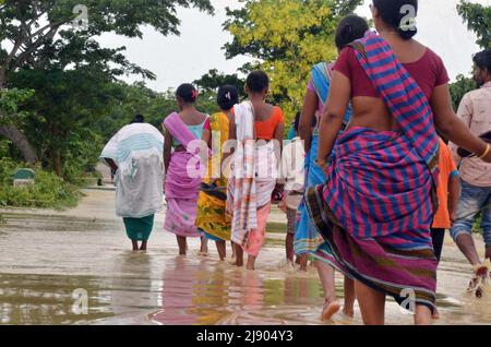 Nagaon (Assam) 19 maggio 2022: Gli abitanti del villaggio che guastano attraverso l'acqua di alluvione come il Nagaon a Kampur strada sommerso in acqua di alluvione al villaggio di Kathiatoli nel distretto di Nagaon di Assam il Giovedi. Foto di DIGANTA TALUKDAR / ALAMY LIVE NEWS Foto Stock