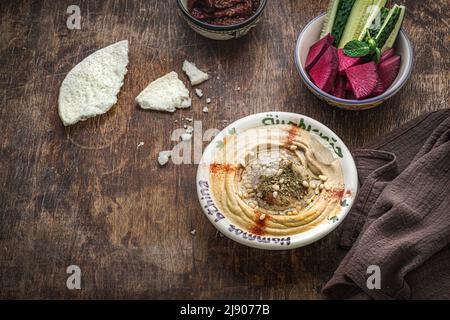 Hummus di ceci con olio d'oliva e paprika affumicata con cetriolo e ravanello Foto Stock