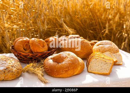 lotto di pane, grano, segale aromatizzato, sulla tavola all'esterno del campo Foto Stock