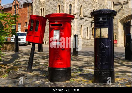 Un British Post Box rosso e blu accanto a un Postage Stamp disputnser sul retro del Castello di Windsor Foto Stock