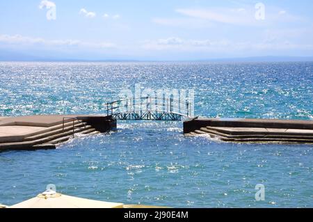 Piccolo ponte a piedi sulla spiaggia di Slatina a Opatija city.Croatia, bella Opatija riviera sul Kvarner, popolare spiaggia Slatina e ponte pedonale in sc Foto Stock