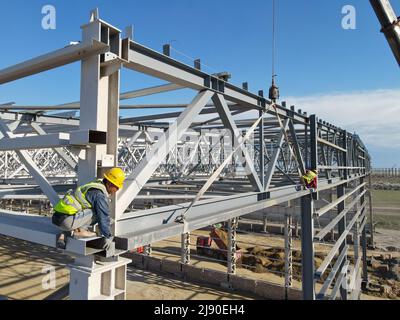 Tacheng. 18th maggio 2022. La foto aerea scattata il 18 maggio 2022 mostra i lavoratori che lavorano in un cantiere a Tacheng, nella regione autonoma di Xinjiang Uygur nella Cina nord-occidentale. I lavoratori edili sono impegnati a costruire importanti progetti infrastrutturali nella zona pilota principale di Tacheng, nella regione autonoma di Xinjiang Uygur, nella Cina nord-occidentale. Credit: Gao Han/Xinhua/Alamy Live News Foto Stock