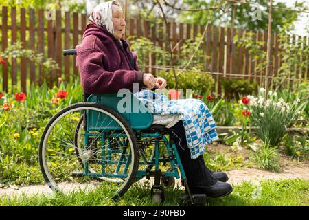 Donna anziana seduta su una sedia a rotelle che sembra triste e preoccupato: Depressione, assistenza sanitaria e cura per gli anziani Foto Stock