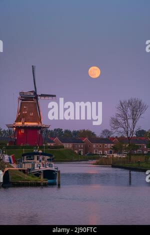 Tramonto e luna piena nei pressi di Flour Mill 'De Hoop' nella città olandese di Dokkum, nella provincia di Frisia nella parte settentrionale della N Foto Stock