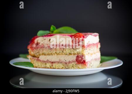 torta di papavero alla fragola con panna in un piatto isolato su sfondo nero Foto Stock