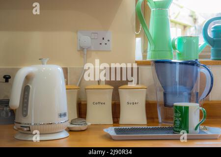 un bollitore e una tazza nella cucina sul piano di lavoro Foto Stock