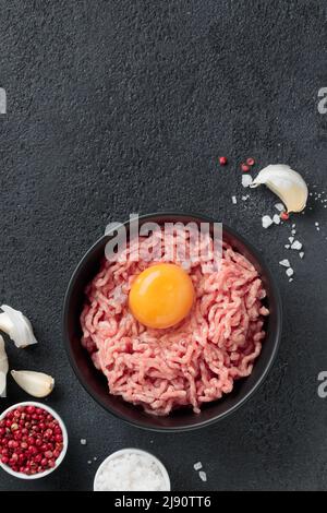 Ingredienti delle cutlet carne di farsa di manzo con uova in un piatto su sfondo nero vista dall'alto Foto Stock