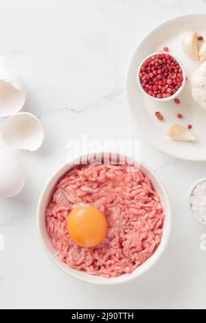 Ingredienti delle cutlet carne di farsa di manzo con uova in un piatto su sfondo bianco vista dall'alto Foto Stock