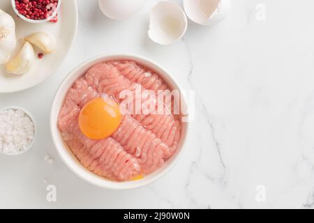 Ingredienti delle cutlet carne di farce con uovo in un piatto su sfondo bianco vista dall'alto Foto Stock