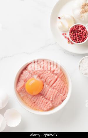 Ingredienti delle cutlet carne di farce con uovo in un piatto su sfondo bianco vista dall'alto Foto Stock