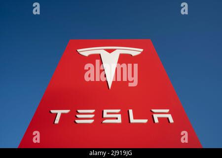 Primo piano di un cartello Tesla visto all'esterno di uno showroom Tesla a Sunnyvale, California, isolato contro un cielo blu chiaro, il 3 maggio 2022. Foto Stock