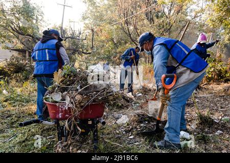 I vicini effettuano una giornata di pulizia in un burrone nella città di Puebla Foto Stock