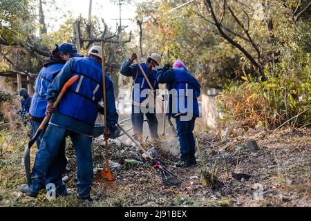 I vicini effettuano una giornata di pulizia in un burrone nella città di Puebla Foto Stock