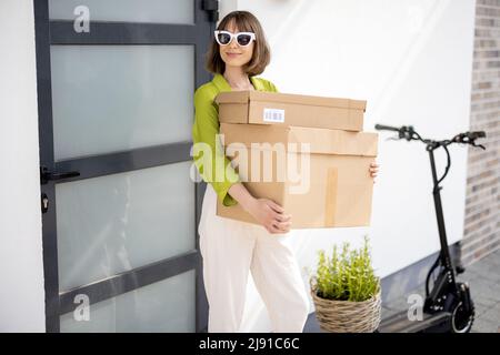 Donna che porta pacchi mentre va a casa Foto Stock
