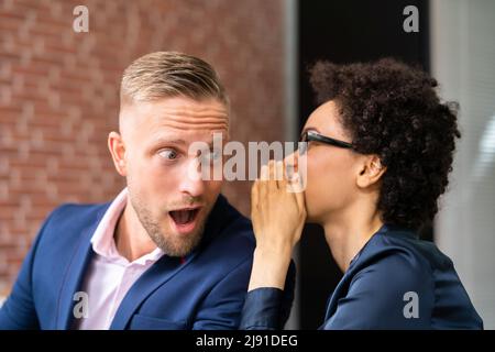 Ritratto di donna felice Whispering segreto o interessante Gossip all uomo bello nel suo orecchio Foto Stock