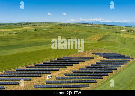 Vista aerea pannelli fotovoltaici parco sul campo verde nel nord della Grecia. Il cielo blu si riflette nelle file dei pannelli solari. Futuristica centrale elettrica alternativa. S Foto Stock