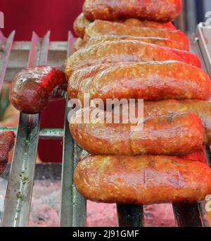 Grandi salsicce cotte sul grill in metallo per la vendita nella stalla Street food Foto Stock