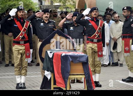 Peshawar, Pakistan. 19th maggio 2022. I poliziotti partecipano ai funerali del loro collega a Peshawar, Pakistan, il 19 maggio 2022. Giovedì due poliziotti, tra cui un ufficiale, sono stati uccisi in un attacco terroristico nella provincia di Khyber Pakhtunkhwa, nella parte nord-occidentale del Pakistan, hanno detto le forze di polizia e le squadre di soccorso. Credit: Saeed Ahmad/Xinhua/Alamy Live News Foto Stock