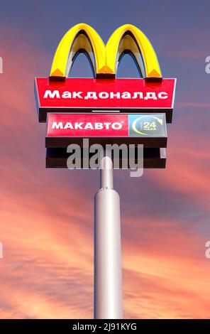 Samara, Russia - 8 maggio 2022: Logo McDonald's su un palo sullo sfondo del cielo del tramonto. McDonald's è la più grande catena al mondo di hamburger fast Foto Stock