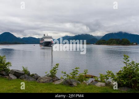 Una nave da crociera ancorata in acqua a Sitka, sull'isola di Baranof in Alaska, USA, con navette ad acqua che trasportano i passeggeri da e per i moli. Foto Stock