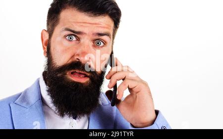 Sorpreso uomo d'affari che chiama con smartphone. Uomo bearded che parla sul telefono delle cellule. Chiamata mobile. Foto Stock