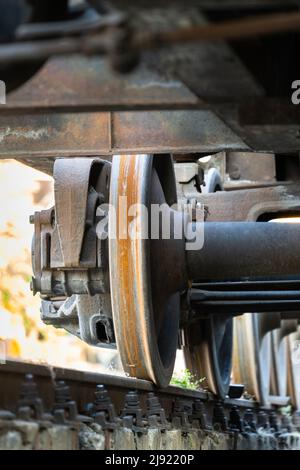 Primo piano di vista di vecchie ruote arrugginite del treno. Telaio ferroviario su rotaia. Foto Stock