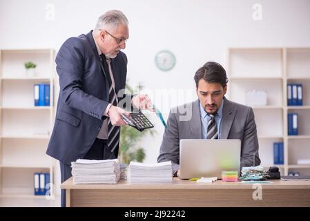 Due contabili maschi nel concetto di pianificazione del budget sul posto di lavoro Foto Stock
