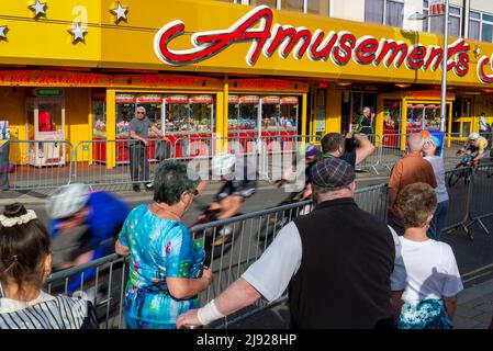 Clacton on Sea, Essex, Regno Unito. 19th maggio 2022. La Sportsbreaks Tour Series 2022 ha raggiunto la città balneare di Clacton on Sea, che ospita una gara maschile seguita da una gara femminile. Ogni gara dura un'ora più cinque giri intorno al circuito lungo 1,4km attraverso la città nel tardo pomeriggio e la sera, con l'inizio e la fine sul lungomare Marine Parade East. Sia le gare maschili che quelle femminili erano composte da 13 squadre, ciascuna delle quali contava un massimo di cinque piloti, il che ha reso possibile un ampio campo di piloti intorno al campo stretto. La gara maschile è stata vinta da Matt Bostock. Ciclisti che passano i divertimenti Foto Stock