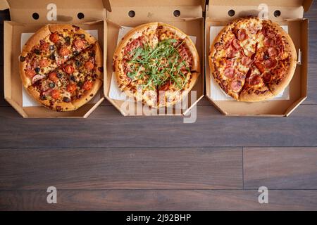 Tre diversi tipi di pizze in scatole di consegna Foto Stock