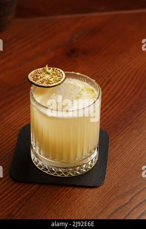 Mixologia della frutta con mezcal e calce secca su tavola in legno. Cocktail dai colori caldi. Cocktail mezcal Foto Stock