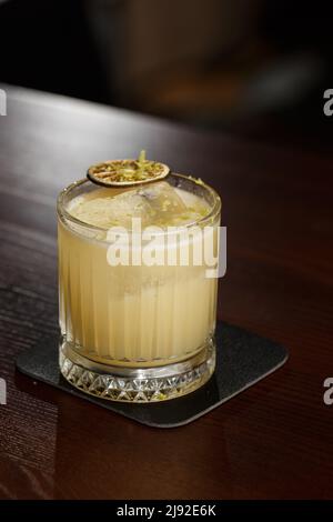 Mixologia della frutta con mezcal e calce secca su tavola in legno. Cocktail dai colori caldi. Cocktail mezcal Foto Stock