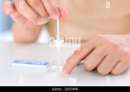 Closeup Woman utilizzando coronavirus covid-19 Rapid Antigen home test kit Foto Stock