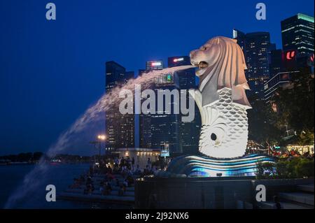 Merlion Park, una statua iconica di Singapore di notte. Merlion è una creatura mitica con la testa di un leone e il corpo di un pesce Foto Stock