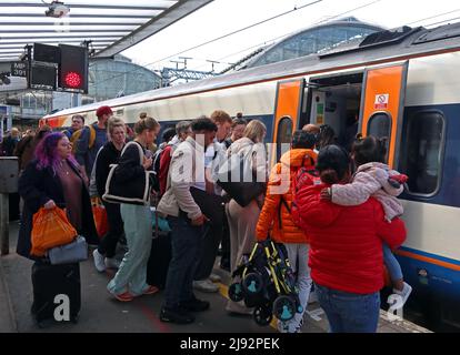 Una folla di passeggeri, sale a Norwich EMR East Midlands Railway DMU treno 57865 a Piccadilly Station, Manchester, Inghilterra, Regno Unito Foto Stock
