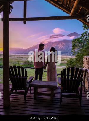 Montagne e praterie vicino Hermanus al percorso giardino Western Cape Sud Africa Whale Coast. Coppia uomo e donna di mezza età di fronte al loro Lodge durante le vacanze in Sud Africa Foto Stock