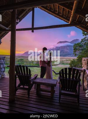 Montagne e praterie vicino Hermanus al percorso giardino Western Cape Sud Africa Whale Coast. Coppia uomo e donna di mezza età di fronte al loro Lodge durante le vacanze in Sud Africa Foto Stock