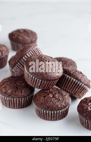 Mucchio di muffin al cioccolato su sfondo bianco Foto Stock