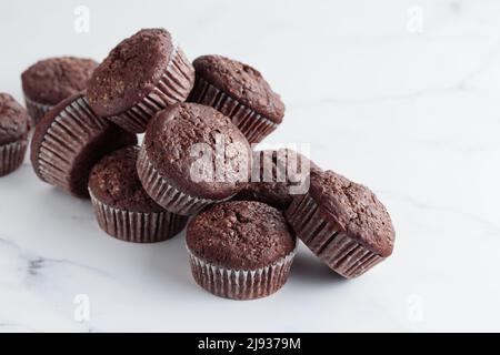 Mucchio di muffin al cioccolato su sfondo bianco Foto Stock