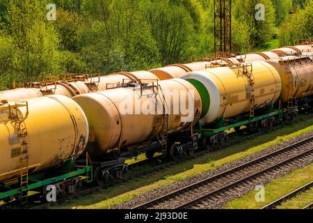 Treni merci che trasportano combustibile liquido in deposito. Serie di serbatoi con trasporto di olio e carburante per ferrovia. Foto Stock