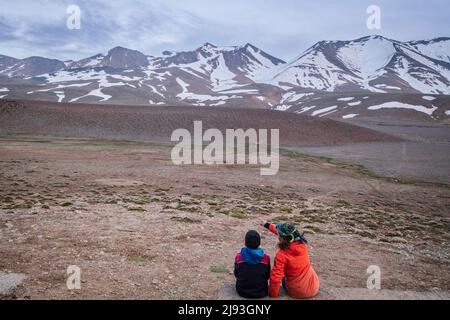 Due bambini osservano la cima di Ighil M'Goun, 4.071 metri, catena montuosa dell'Atlante, marocco, africa Foto Stock