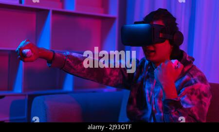 Metaverse Technology Concept, uomo indossare occhiali VR e divertirsi a giocare a boxe nel mondo virtuale. Foto Stock