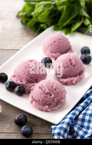 Misurini per gelato al mirtillo su tavola di legno Foto Stock