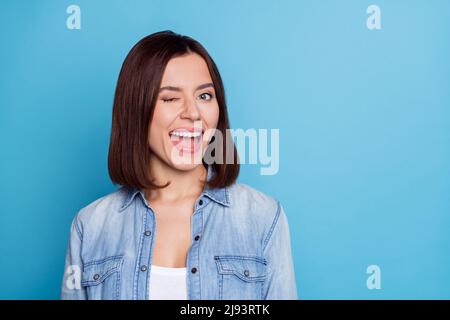 Foto di ragazza entusiasta vestita denim camicia che vagliano spazio vuoto isolato blu sfondo colore Foto Stock