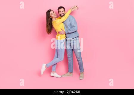 Foto a grandezza naturale di due simpatici partner abbracciare godere del tempo libero insieme isolato su sfondo rosa Foto Stock