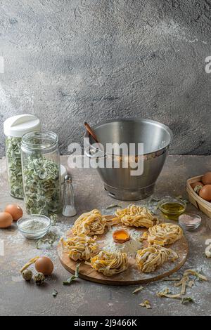 Tagliatelle appena fatte con uova e farina su tavola di legno Foto Stock