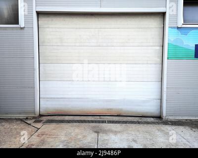 Grunge Old Metal Automatic Door su Rusty pannello esterno parete sfondo Foto Stock