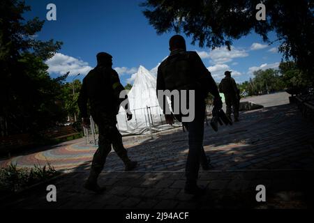 Barvinkove, Kharkiv Oblast, Ucraina. 20th maggio 2022. Il sindaco di Barvinkove Alexander Balo, centro, cammina con una scorta a Barvinkove, Ucraina, il 20 maggio 2022. Le forze russe stanno avanzando da Izyum, una città locale vicina, verso Barvinkove mentre tentano di catturare la regione di Donbas. (Credit Image: © Daniel Carde/ZUMA Press Wire) Foto Stock